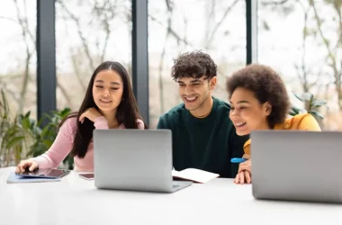 depositphotos_665774198-stock-photo-happy-college-students-sharing-laptop